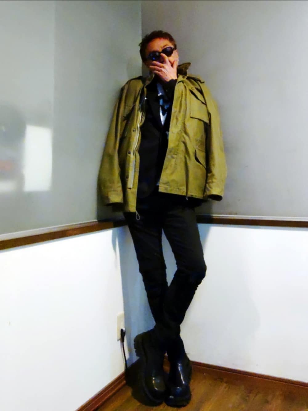 ブラック系のテーラードジャケット、ブラック系のデニムパンツ、ブラック系のブーツを着用したメンズの春コーディネートの2枚目の写真