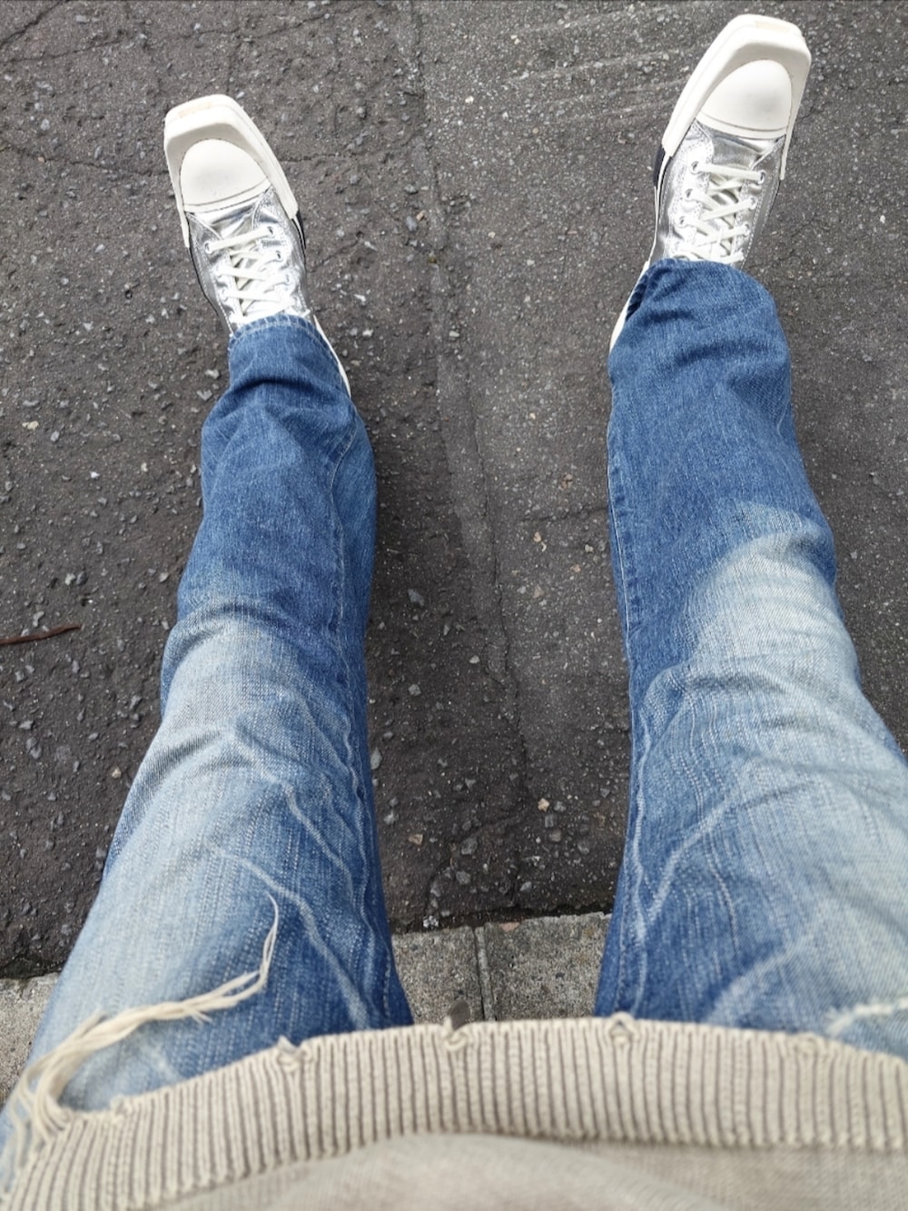 ベージュ系のニット/セーター、ブルー系のデニムパンツ、シルバー系のスニーカーを着用したメンズの秋コーディネートの3枚目の写真