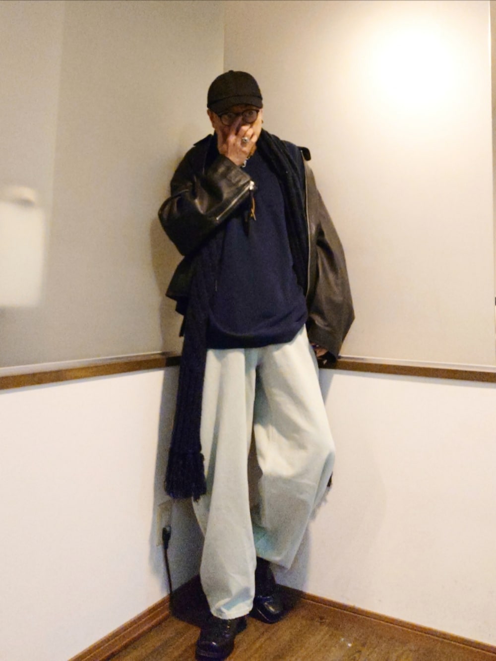 ブラック系のブルゾン、ブルー系のデニムパンツ、ブラック系のブーツを着用したメンズの秋コーディネートの2枚目の写真