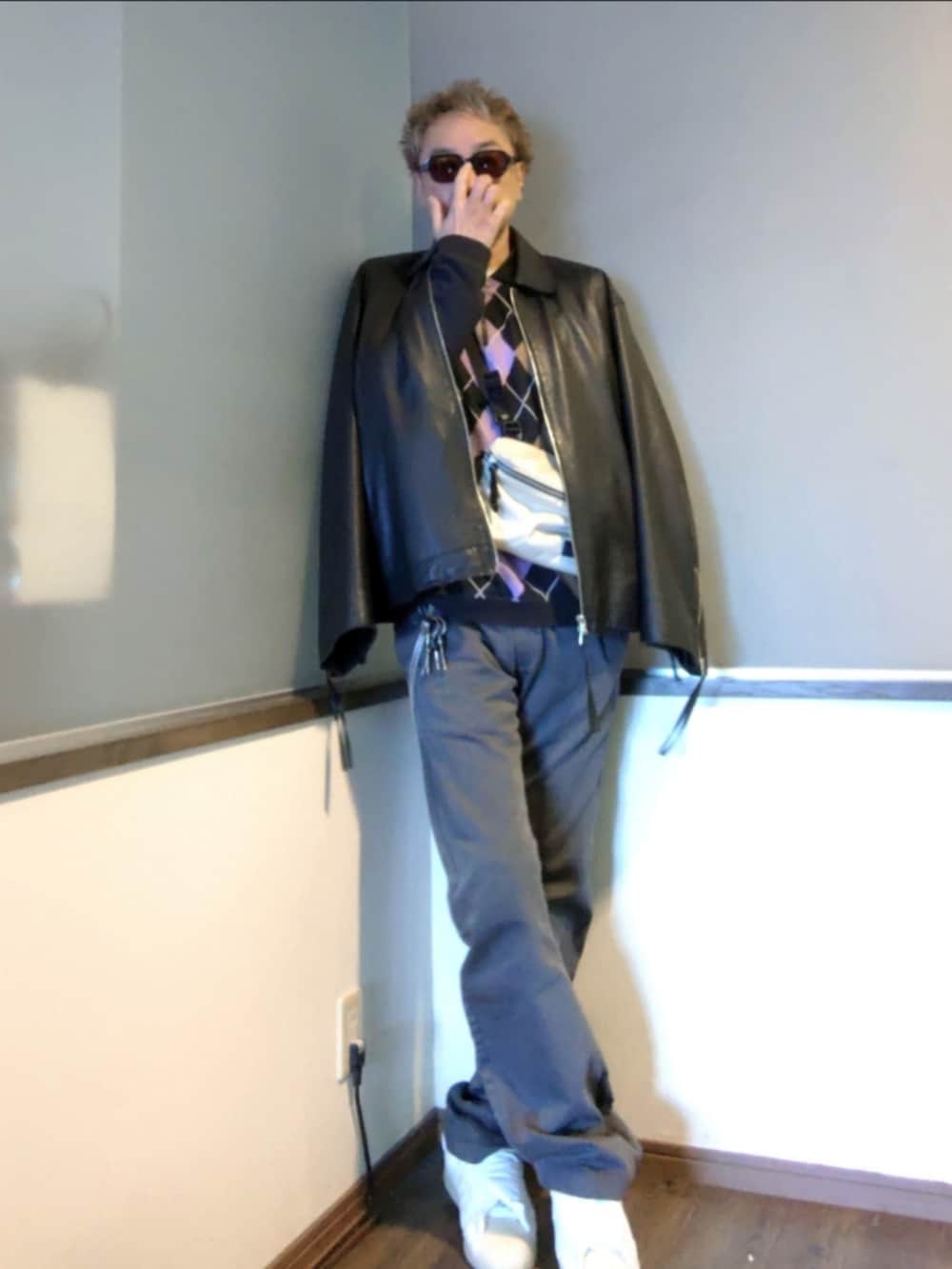 ブラック系のポロシャツ、ブラック系のブルゾン、ホワイト系のショルダーバッグを着用したメンズの春コーディネートの2枚目の写真