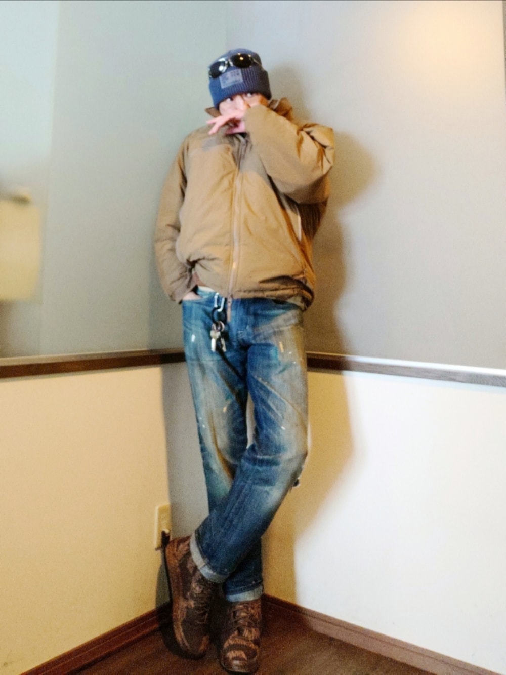 ブラウン系のベスト、ベージュ系のダウンジャケット/コート、ブルー系のデニムパンツを着用したメンズの冬コーディネートの2枚目の写真