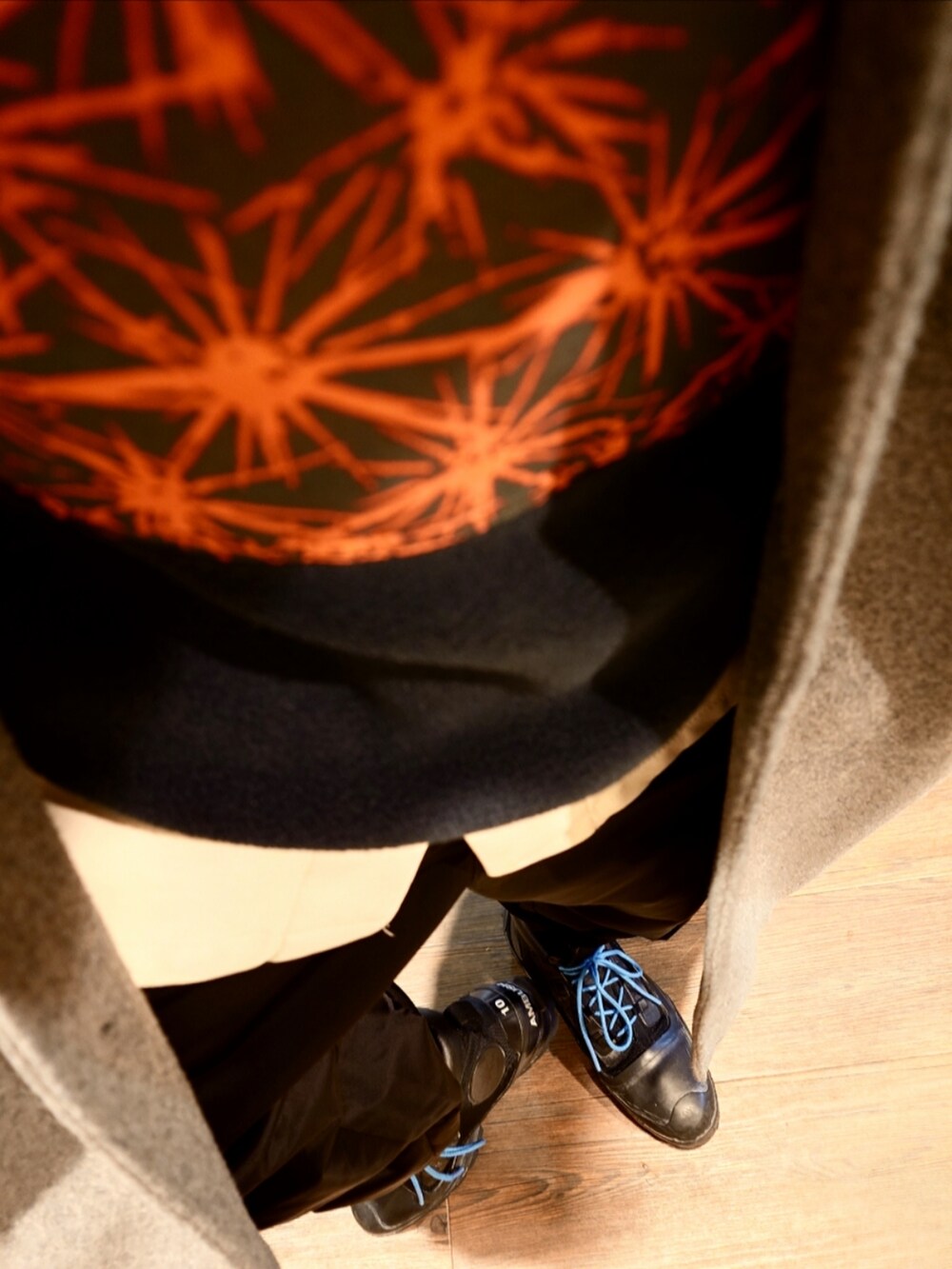 レッド系のブルゾン、グレー系のチェスターコート、ホワイト系のシャツ/ブラウスを着用したメンズの冬コーディネートの4枚目の写真