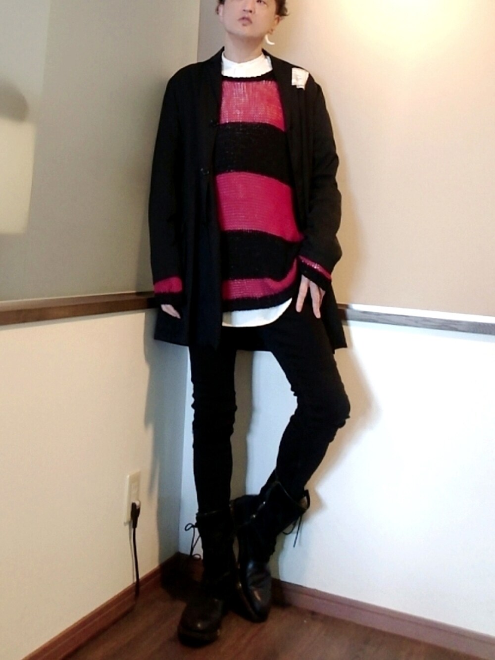 レッド系のニット/セーター、ブラック系のデニムパンツ、ブラック系のブーツを着用したメンズの春コーディネートの2枚目の写真