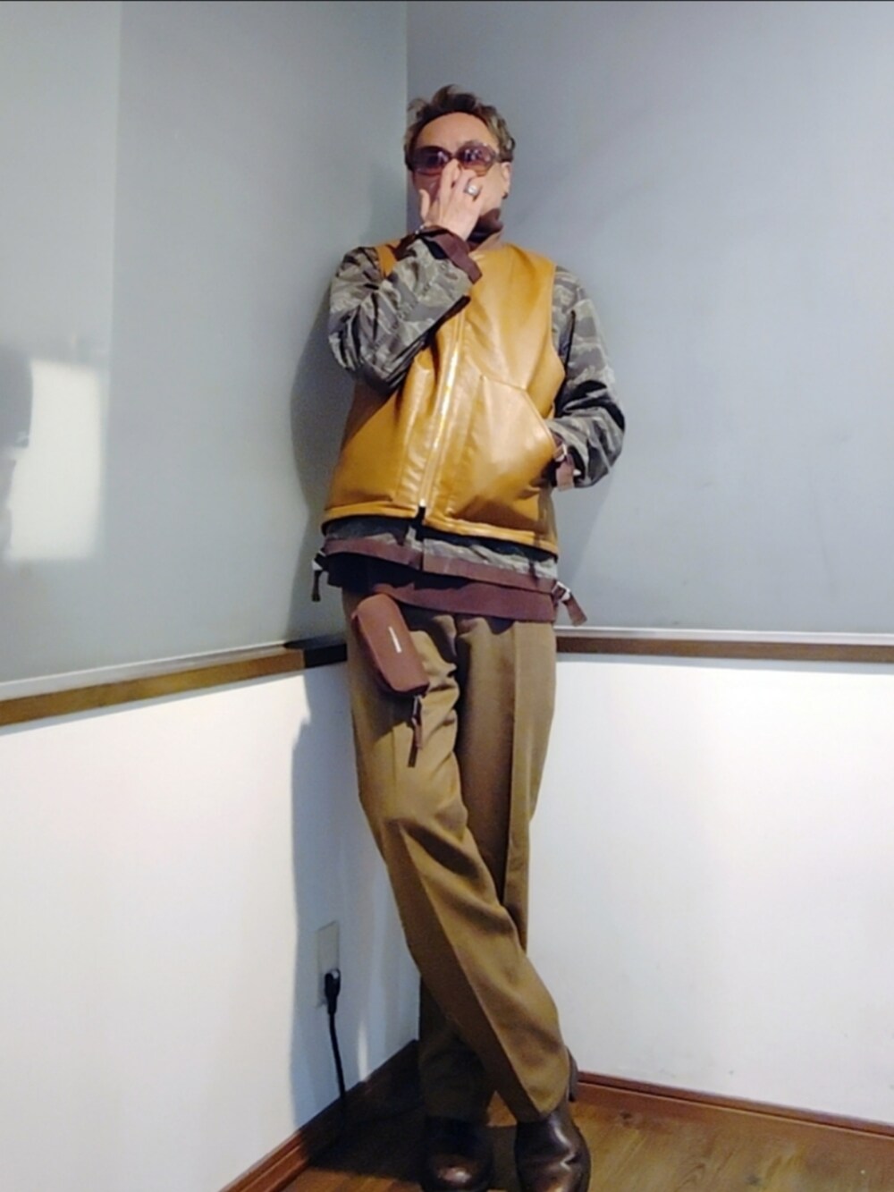 ブラウン系のダウンベスト、グリーン系のミリタリージャケット、ブラウン系のニット/セーターを着用したメンズの秋コーディネートの3枚目の写真