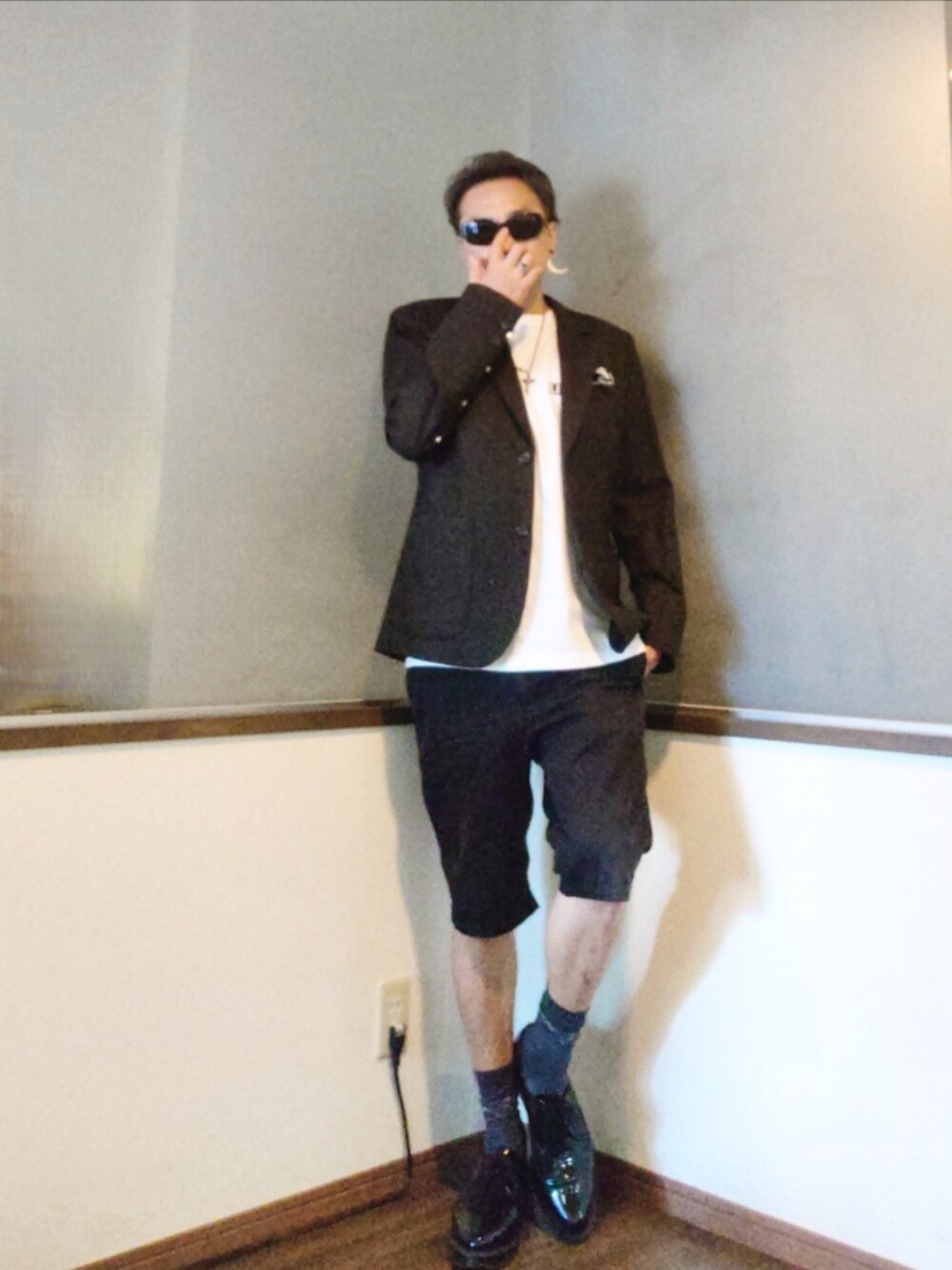 グレー系のテーラードジャケット、ホワイト系のTシャツ/カットソー、ブラック系のチノパンツを着用したメンズの秋コーディネートの2枚目の写真