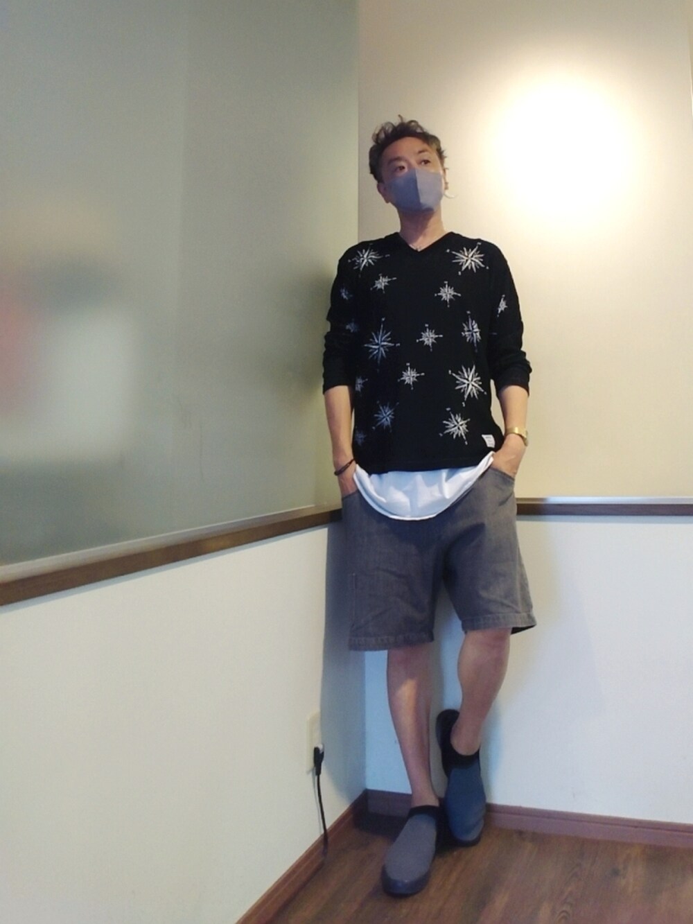 ブラック系のニット/セーター、ホワイト系のTシャツ/カットソー、ブラック系のデニムパンツを着用したメンズの夏コーディネートの2枚目の写真