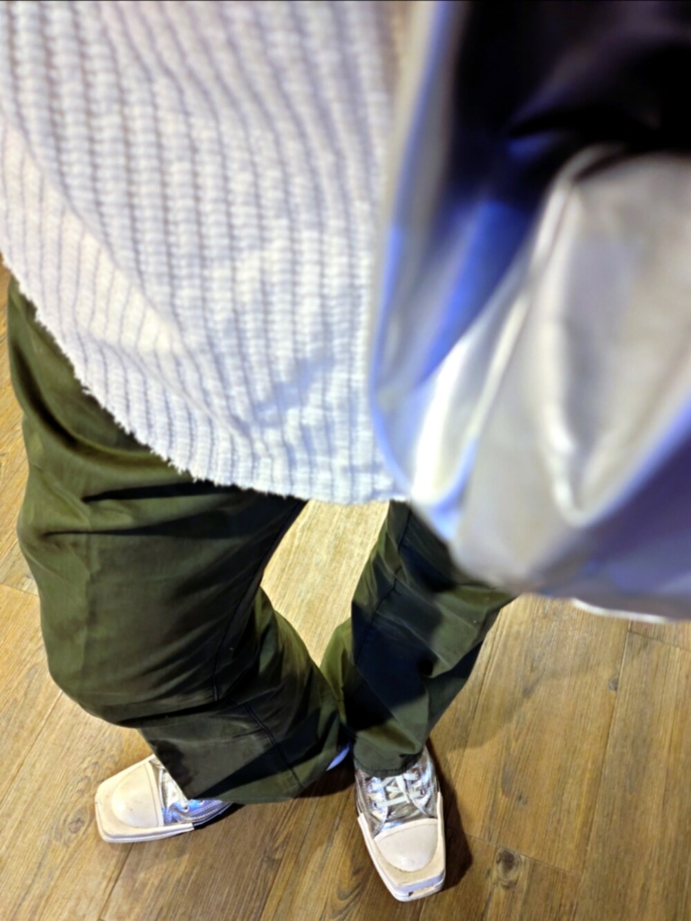 ベージュ系のTシャツ/カットソー、シルバー系のトートバッグ、グリーン系のスラックスを着用したメンズの秋コーディネートの3枚目の写真