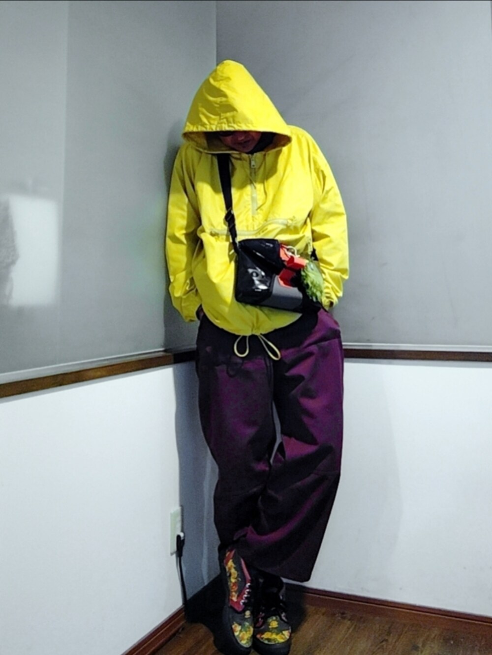 グレー系のスウェット、レッド系のパンツ、イエロー系のナイロンジャケットを着用したメンズの秋コーディネートの3枚目の写真