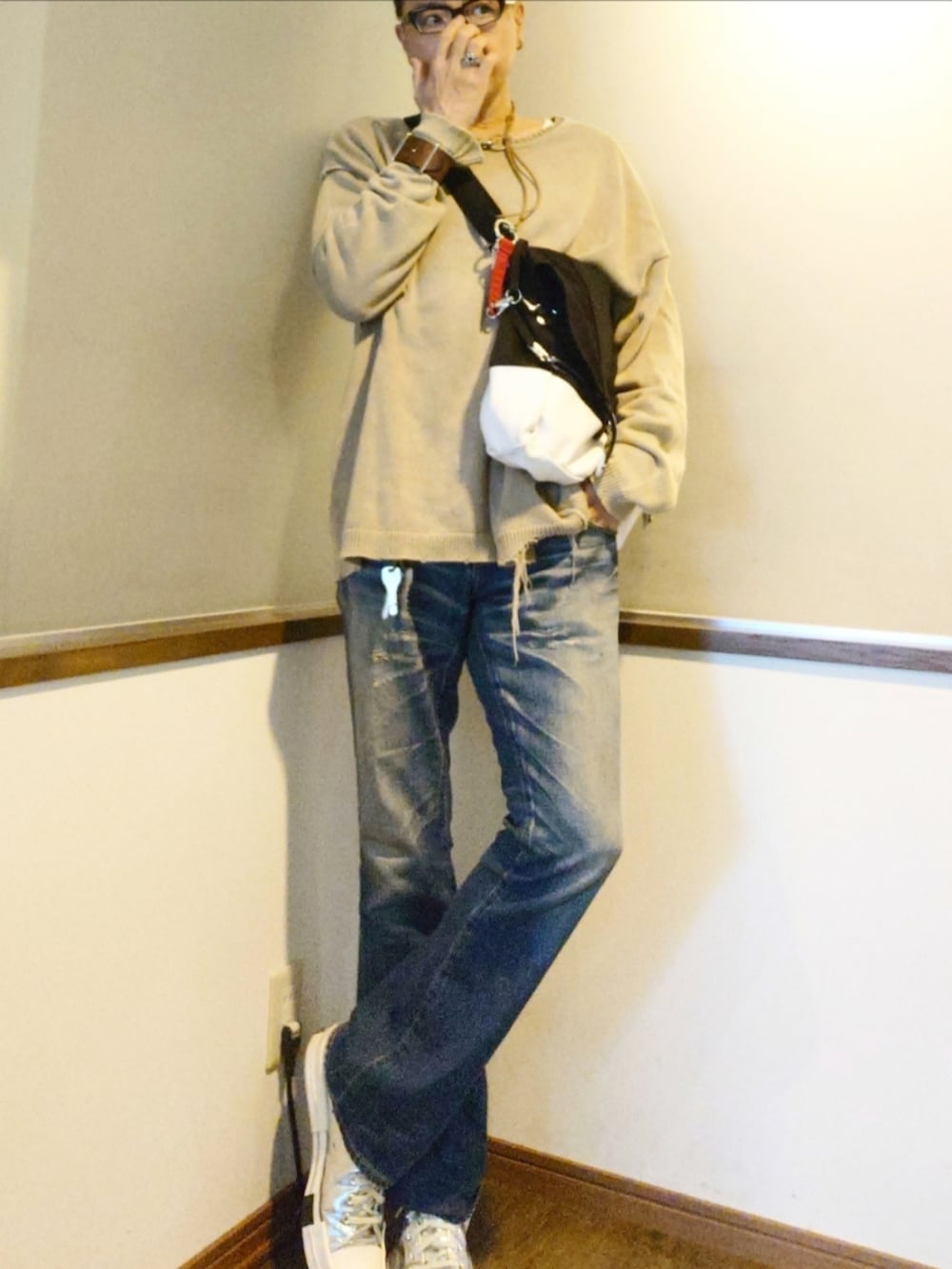 ベージュ系のニット/セーター、ブルー系のデニムパンツ、シルバー系のスニーカーを着用したメンズの秋コーディネートの2枚目の写真