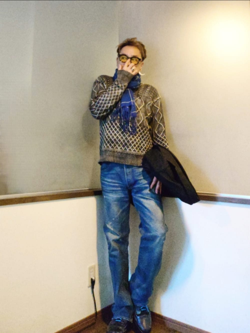 ブラック系のスニーカー、ブラック系のスニーカー、ブルー系のデニムパンツを着用したメンズの秋コーディネートの2枚目の写真