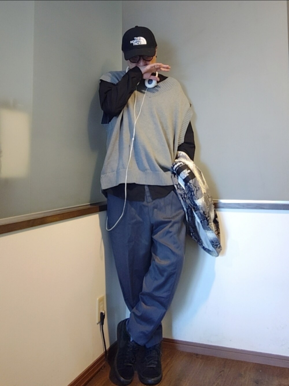 ホワイト系のナイロンジャケット、グレー系のスラックス、ブラック系のスニーカーを着用したメンズの秋コーディネートの2枚目の写真