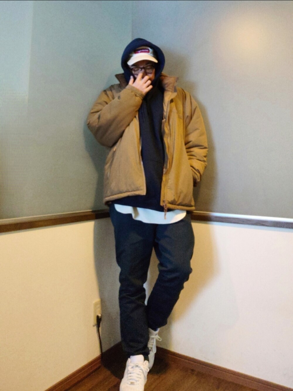 ベージュ系のダウンジャケット/コート、ブルー系のパーカー、ブルー系のパンツを着用したメンズの冬コーディネートの3枚目の写真