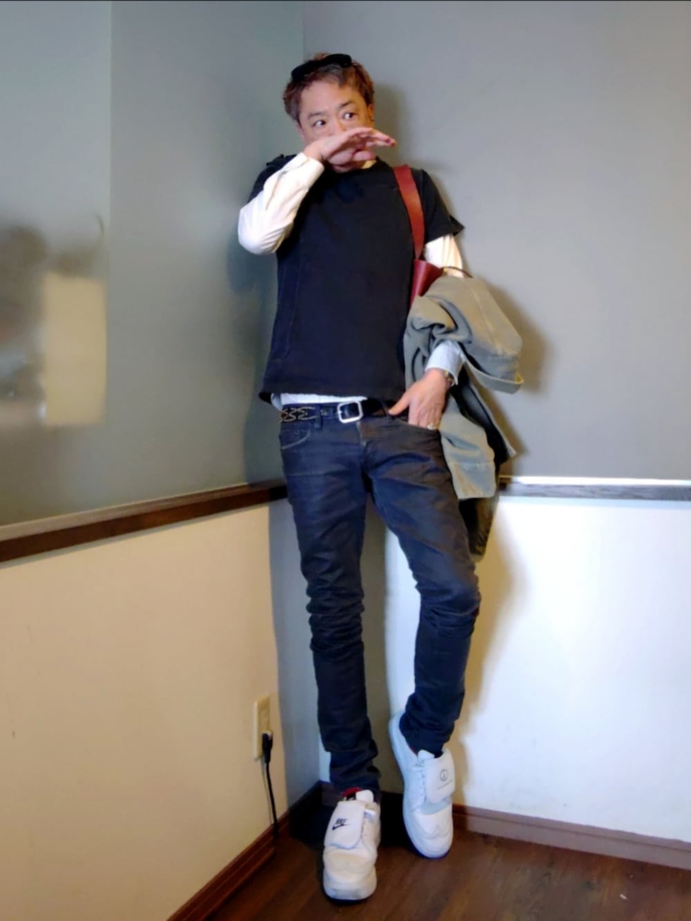 グレー系のデニムパンツ、ホワイト系のドレスシューズ、レッド系のトートバッグを着用したメンズの春コーディネートの2枚目の写真