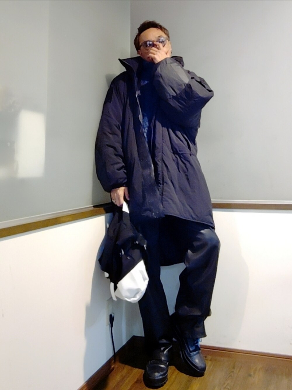 ブルー系のニット/セーター、ブラック系のダウンジャケット/コート、ブラック系のその他パンツを着用したメンズの冬コーディネートの3枚目の写真