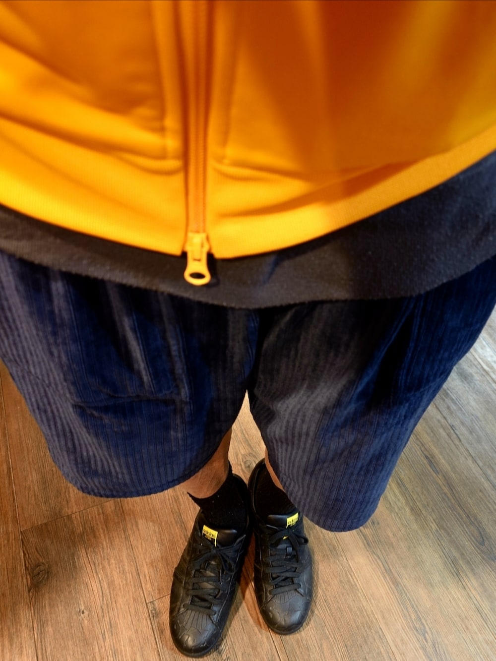 イエロー系のジャージ、ブルー系のその他パンツ、ブラック系のスニーカーを着用したメンズの秋コーディネートの2枚目の写真