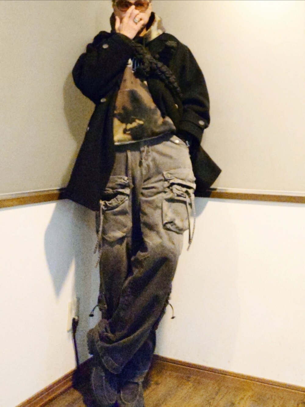 ブラック系のパーカー、ブラック系のショルダーバッグ、ブラック系のピーコートを着用したメンズの冬コーディネートの2枚目の写真