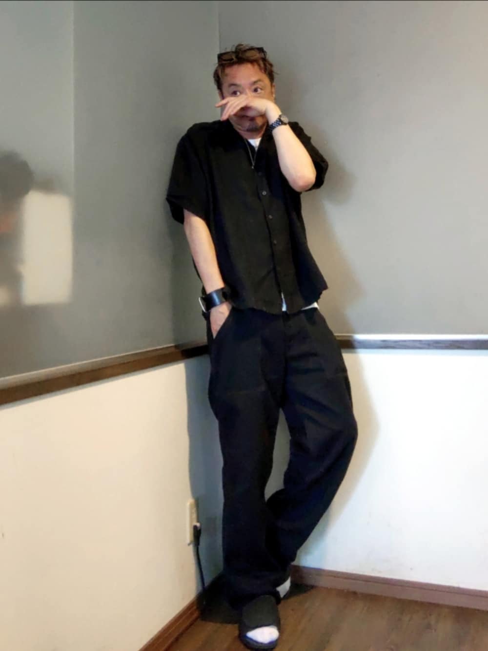 ブラック系のシャツ/ブラウス、ブラック系のチノパンツ、ブラック系のサンダルを着用したメンズの夏コーディネートの3枚目の写真