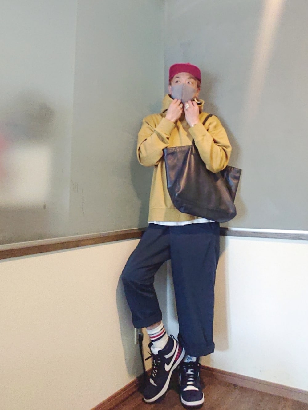 イエロー系のパーカー、ブルー系のチノパンツ、ブルー系のトートバッグを着用したメンズの夏コーディネートの3枚目の写真