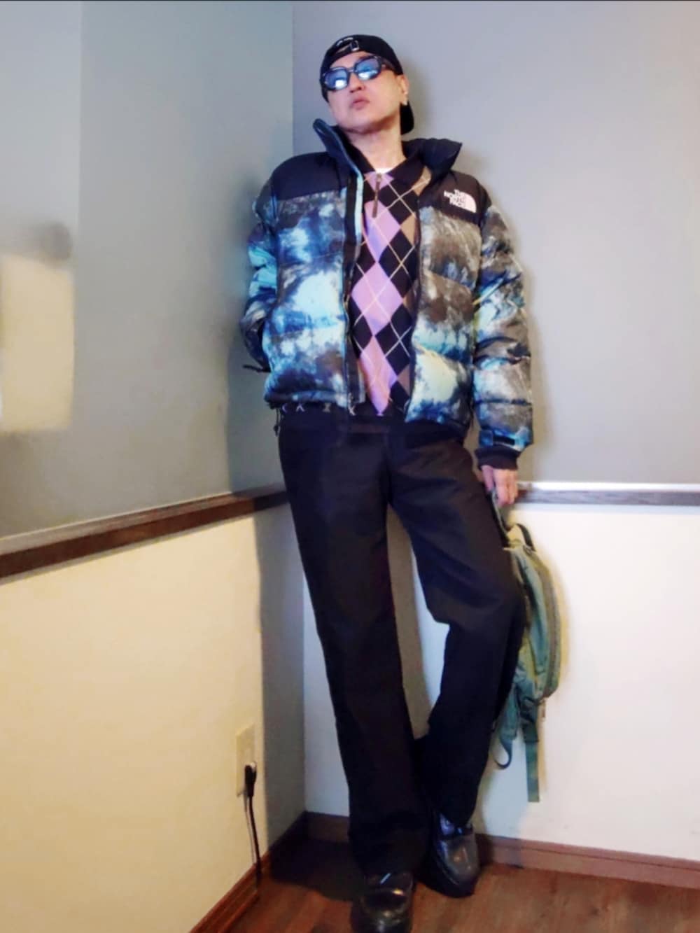 ブルー系のダウンジャケット/コート、ブラック系のポロシャツ、グリーン系のボディバッグ/ウエストポーチを着用したメンズの冬コーディネートの3枚目の写真