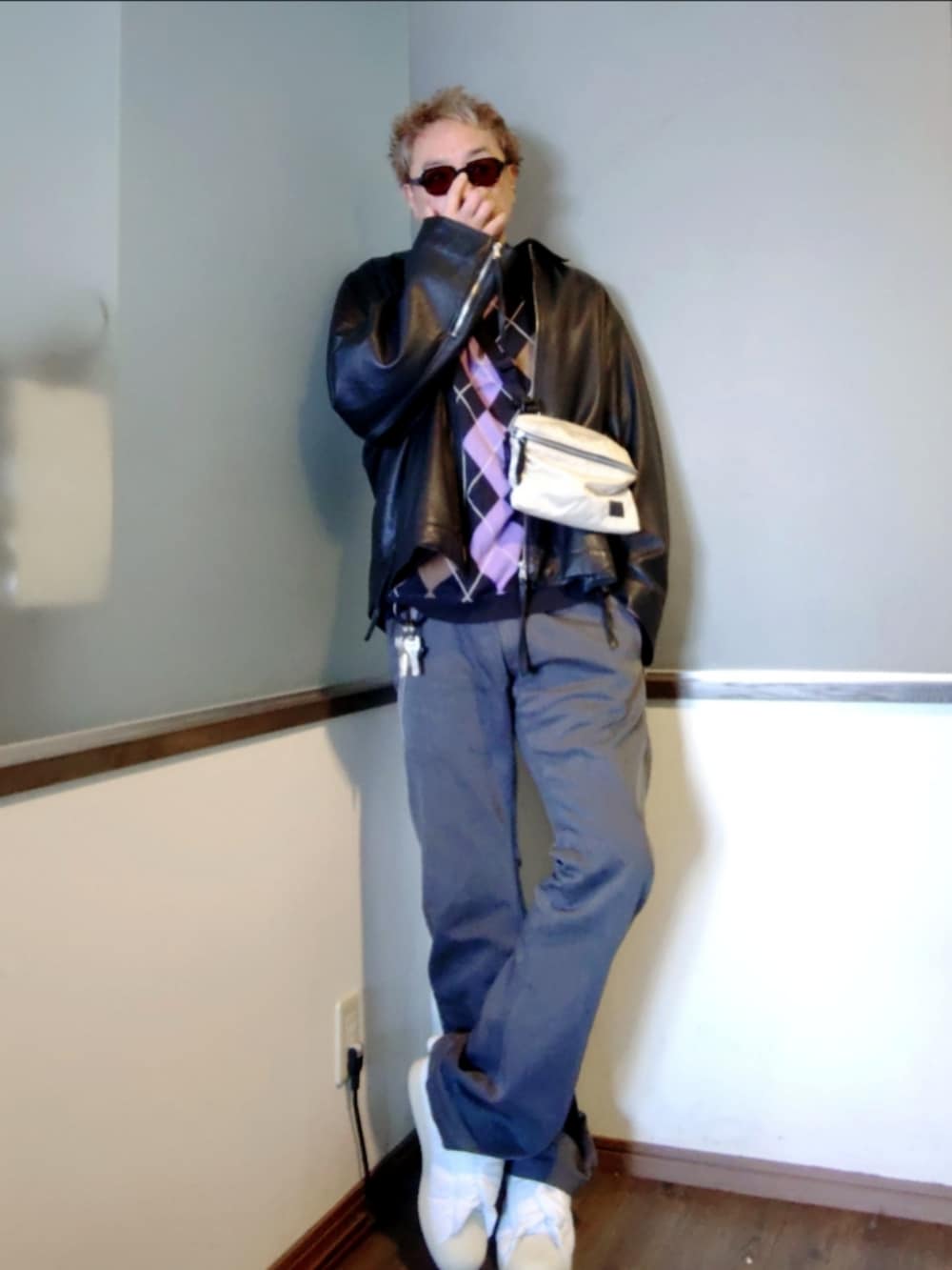 ブラック系のポロシャツ、ブラック系のブルゾン、ホワイト系のショルダーバッグを着用したメンズの春コーディネートの3枚目の写真