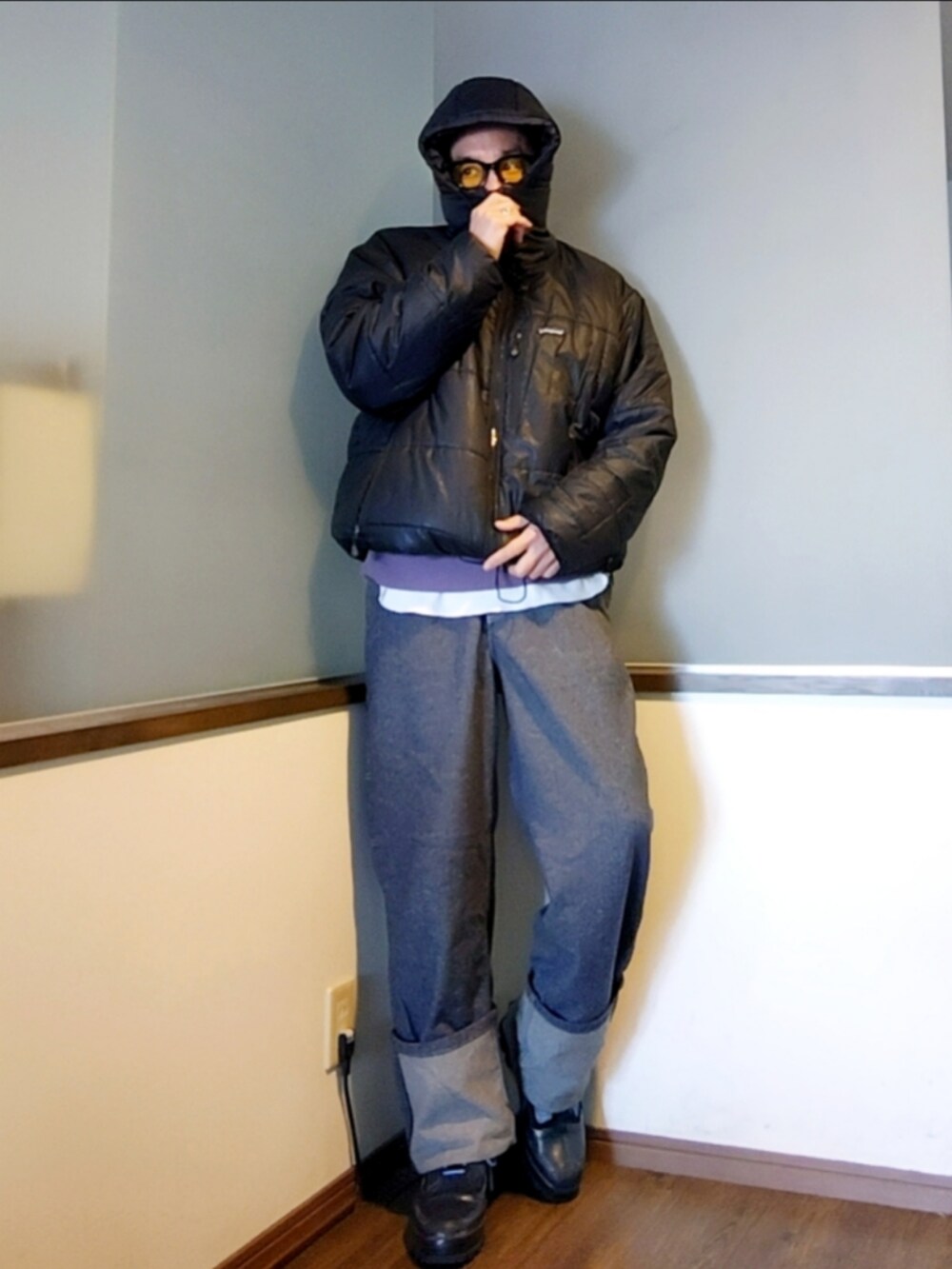 ブラック系のダウンジャケット/コート、パープル系のニット/セーター、ブルー系のデニムパンツを着用したメンズの冬コーディネートの2枚目の写真