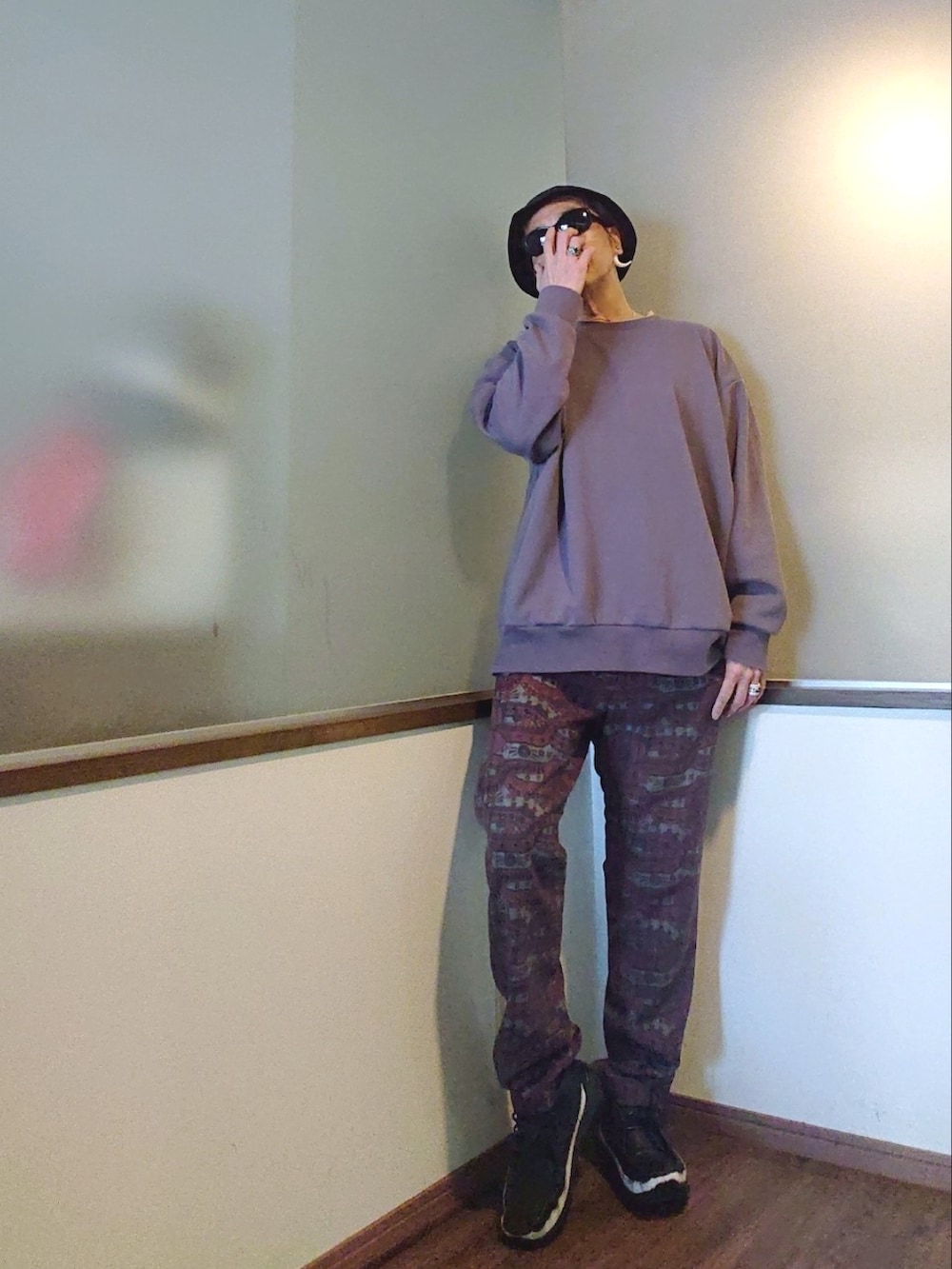 パープル系のスウェット、レッド系のパンツ、ブラック系のブーツを着用したメンズの春コーディネートの2枚目の写真