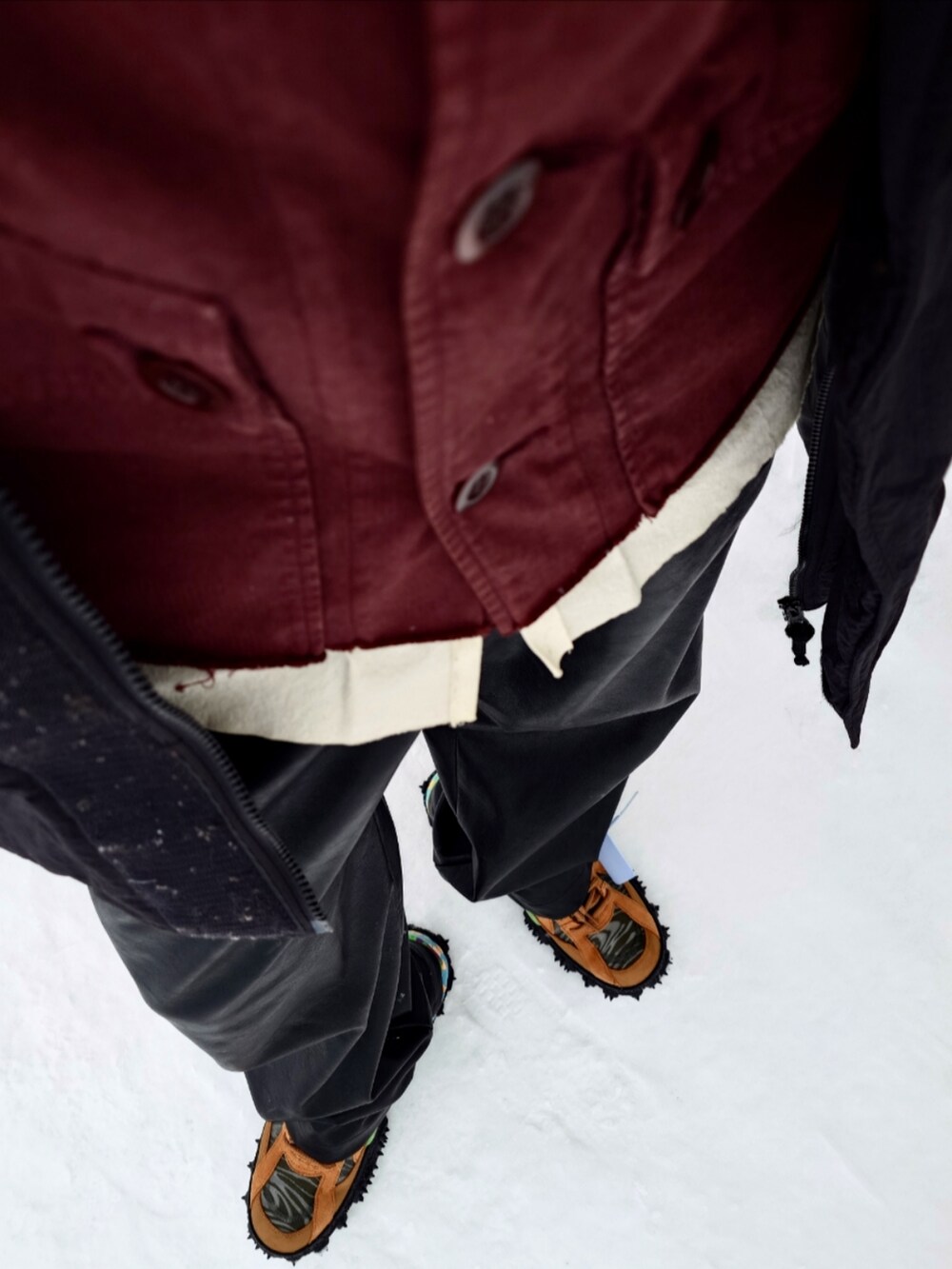 ブラック系のダウンジャケット/コート、レッド系のカバーオール、ブラック系のその他パンツを着用したメンズの冬コーディネートの5枚目の写真