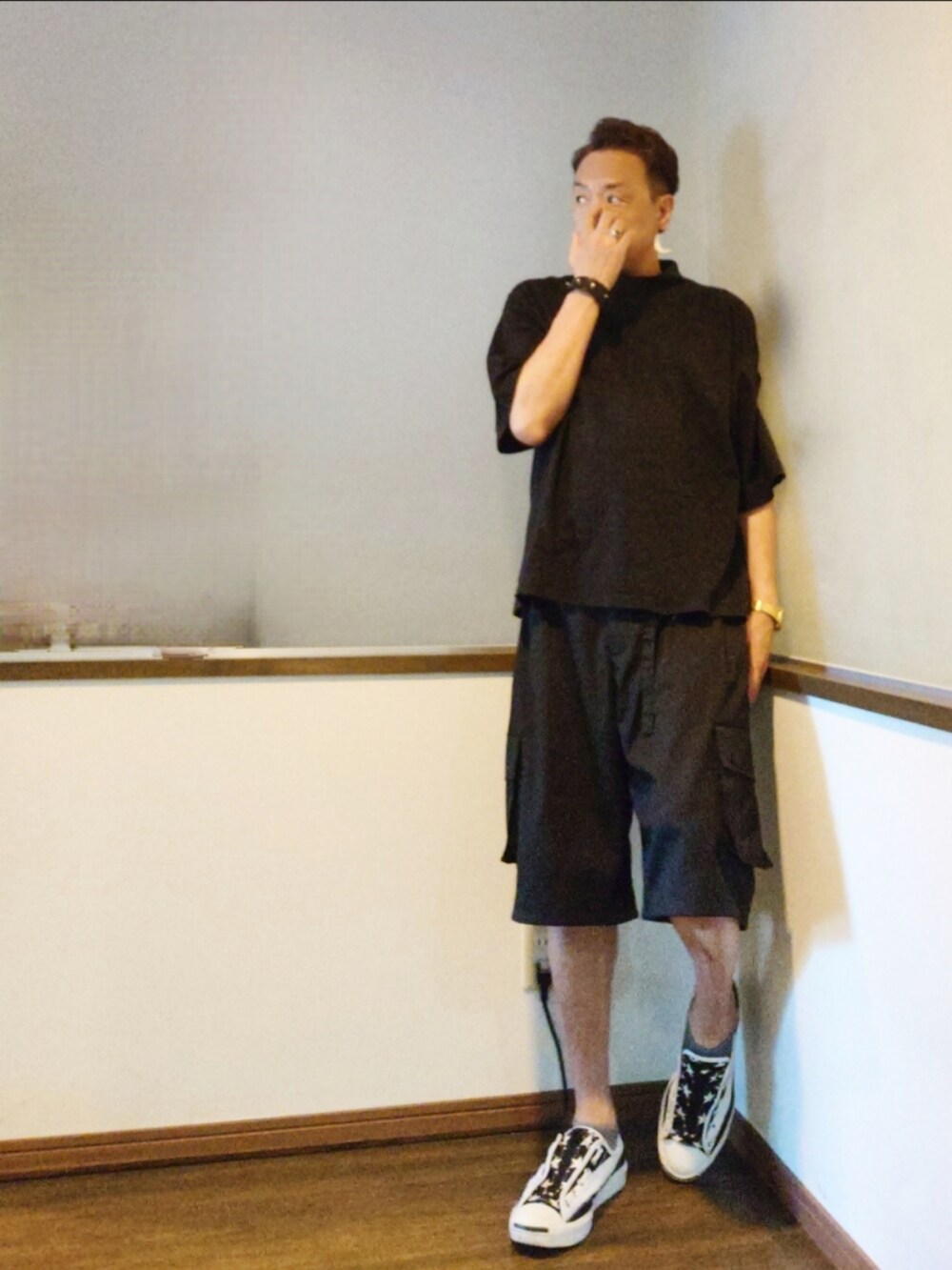 ブラック系のTシャツ/カットソー、ブラック系のカーゴパンツ、ホワイト系のスニーカーを着用したメンズの夏コーディネートの2枚目の写真