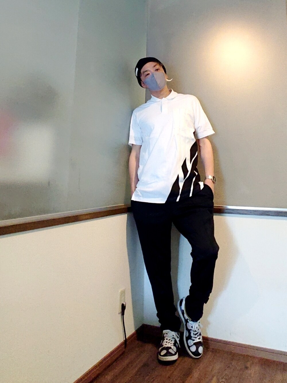 ホワイト系のポロシャツ、ブラック系のその他パンツ、ブラック系のスニーカーを着用したメンズの夏コーディネートの2枚目の写真