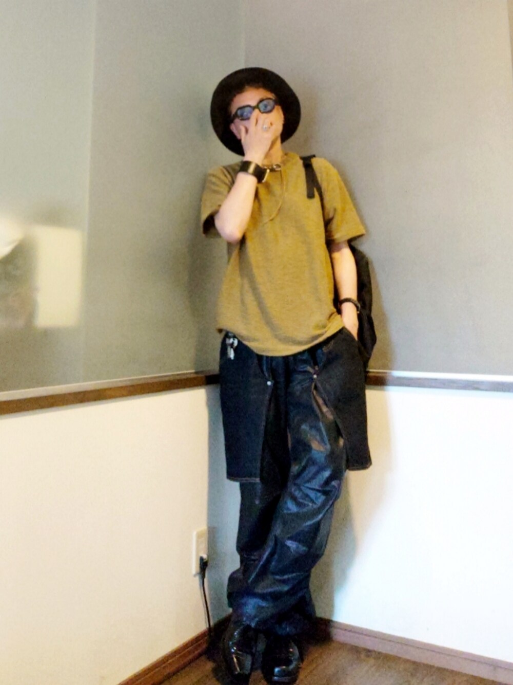 グリーン系のニット/セーター、ブルー系のデニムパンツ、ブラック系のブーツを着用したメンズの夏コーディネートの2枚目の写真