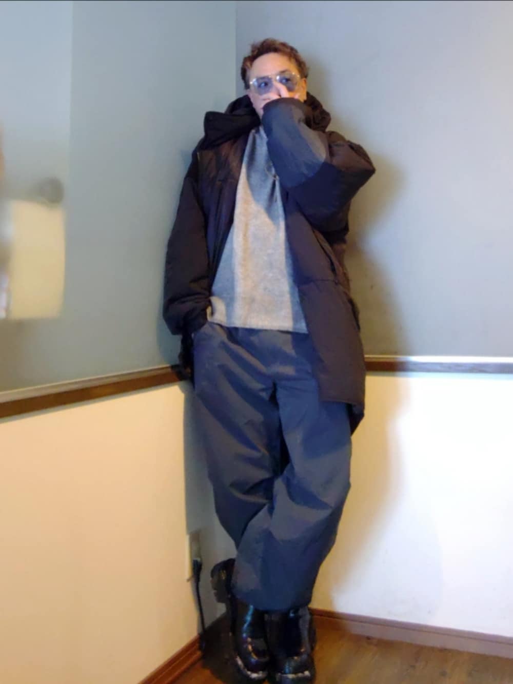 ブラック系のダウンジャケット/コート、グレー系のニット/セーター、グレー系のカーゴパンツを着用したメンズの冬コーディネートの2枚目の写真