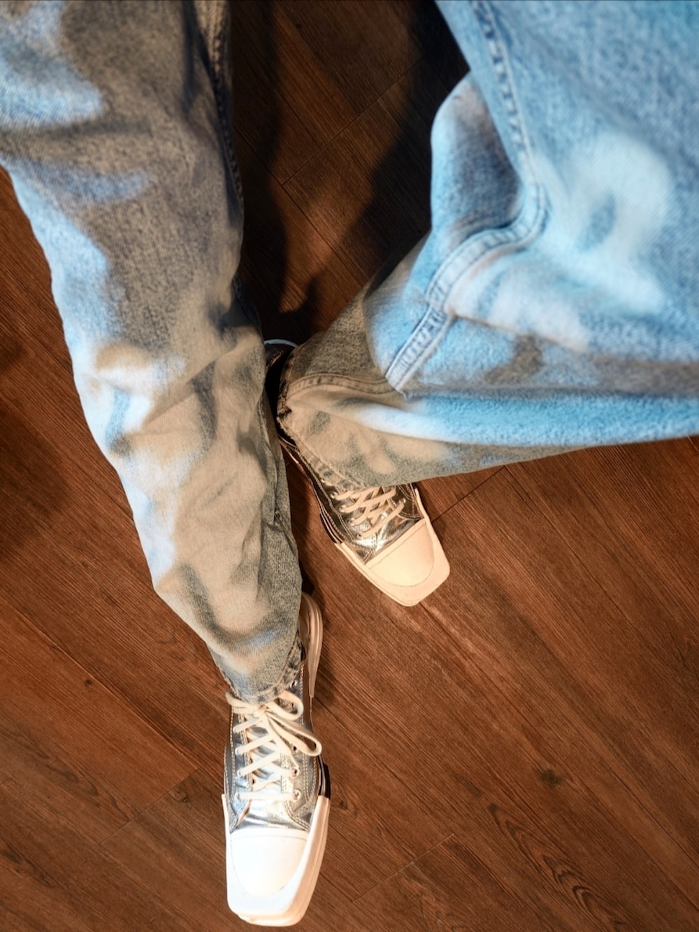 ブルー系のデニムパンツ、ブルー系のニット/セーター、シルバー系のスニーカーを着用したメンズの夏コーディネートの2枚目の写真