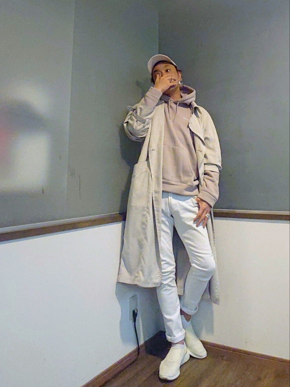 ベージュ系のパーカー、ホワイト系のトレンチコート、ホワイト系のデニムパンツを着用したメンズの春コーディネートの2枚目の写真