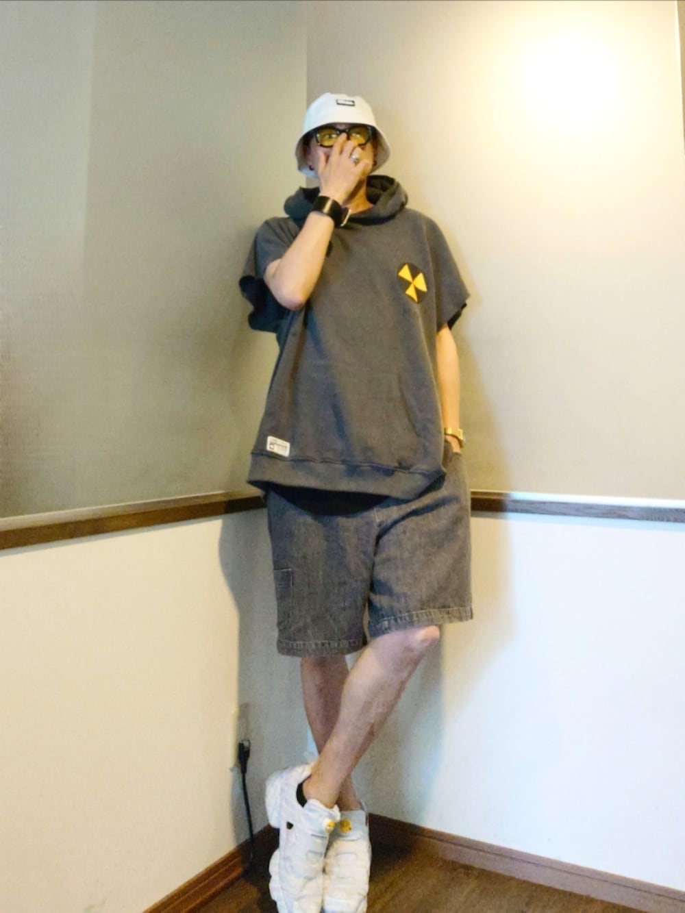 グレー系のパーカー、ホワイト系のスニーカー、ブラック系のデニムパンツを着用したメンズの夏コーディネートの2枚目の写真