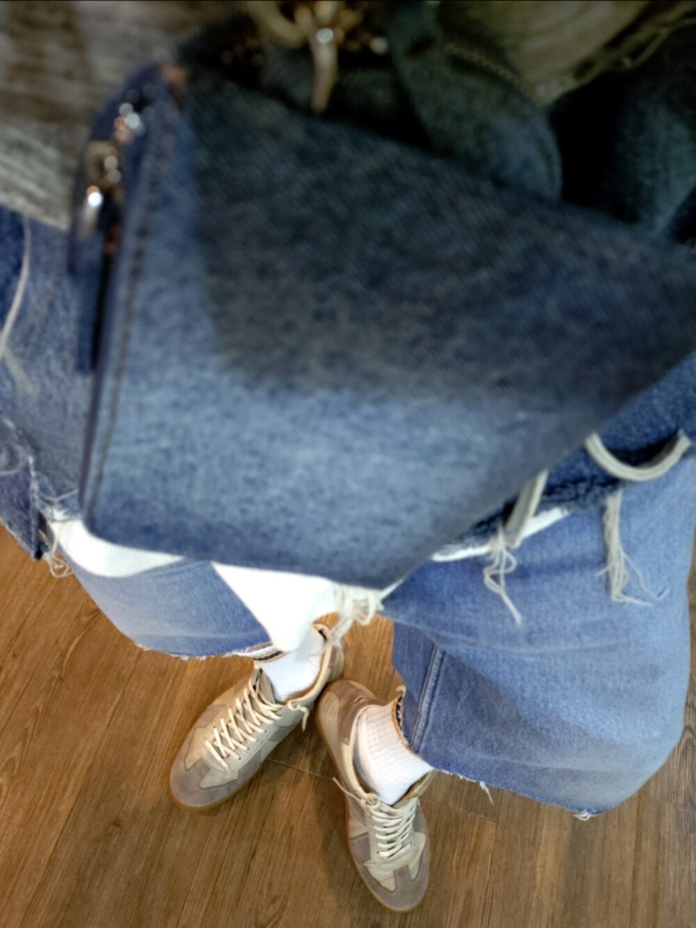 ブルー系のデニムパンツ、グレー系のスニーカー、ブルー系のショルダーバッグを着用したメンズの秋コーディネートの4枚目の写真