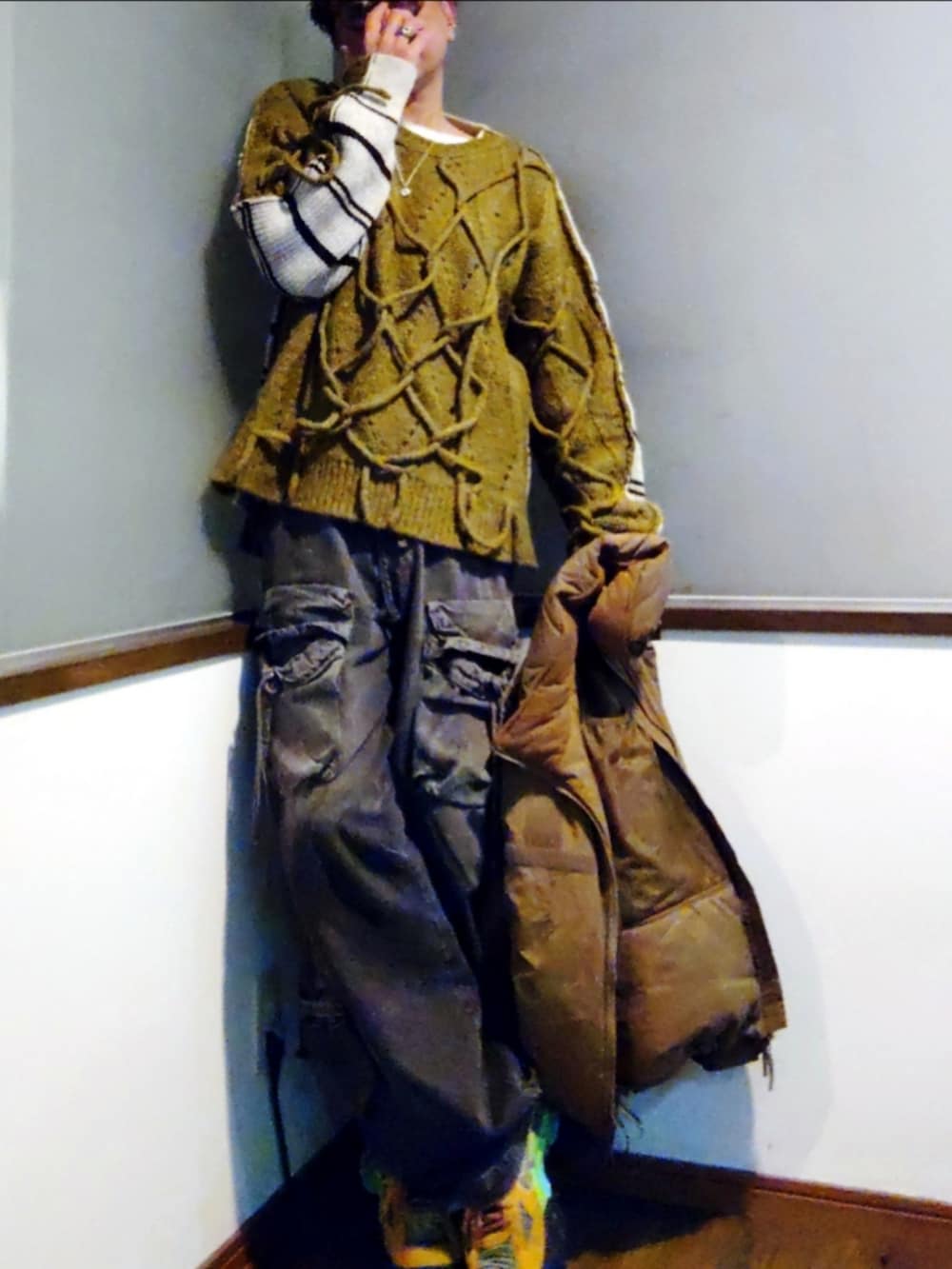 グリーン系のニット/セーター、ベージュ系のダウンジャケット/コート、ブラック系のカーゴパンツを着用したメンズの冬コーディネートの3枚目の写真