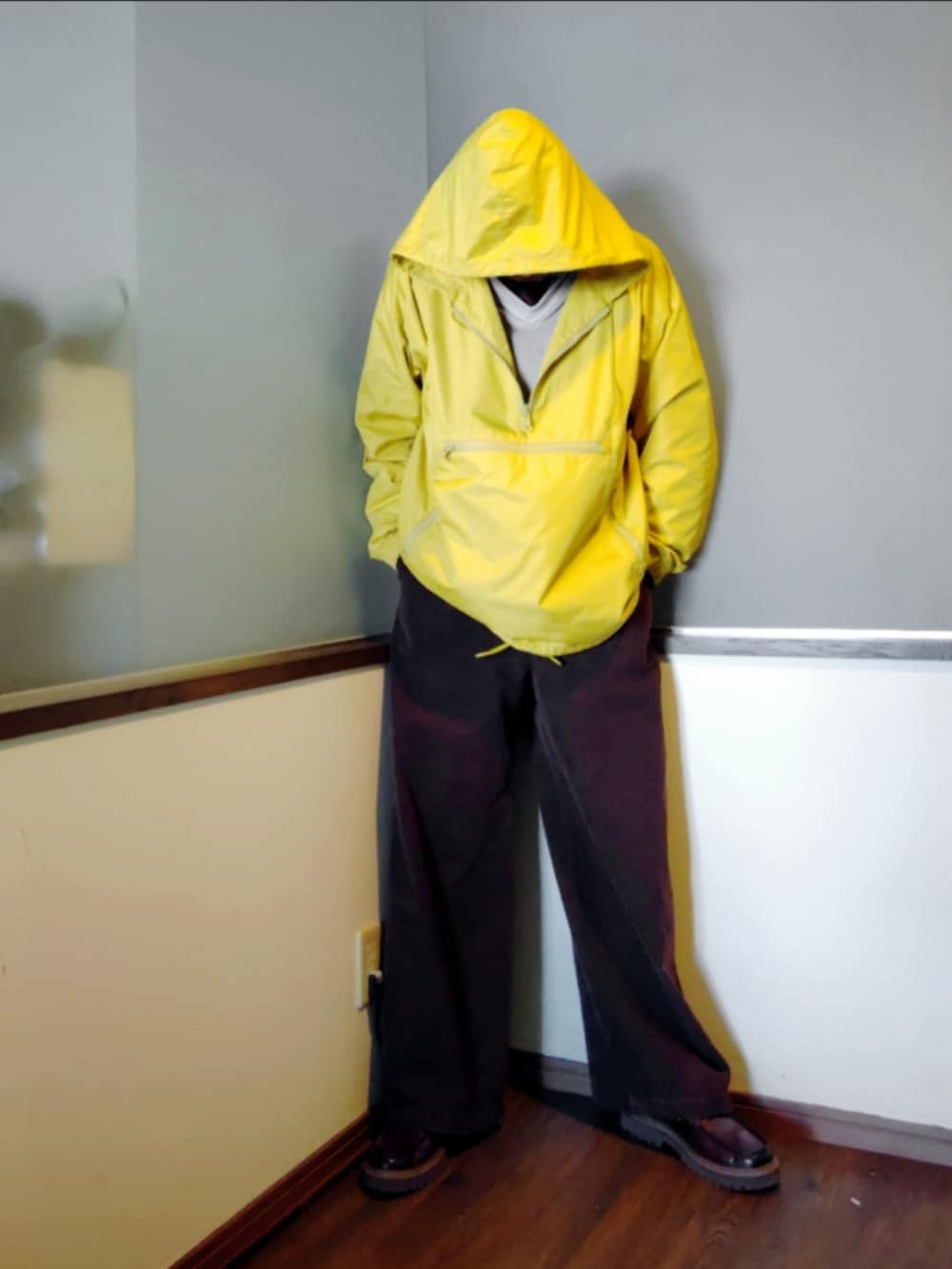 イエロー系のナイロンジャケット、ブラウン系のスラックス、ホワイト系のスウェットを着用したメンズの春コーディネートの3枚目の写真