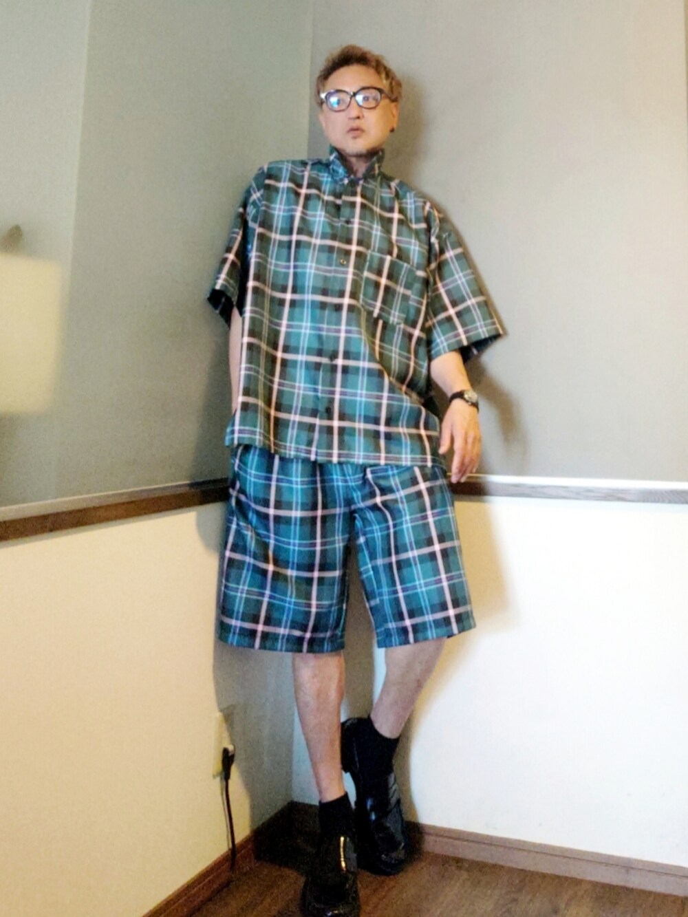 グリーン系のセットアップ、ブルー系のTシャツ/カットソー、ブラック系のローファーを着用したメンズの夏コーディネートの4枚目の写真