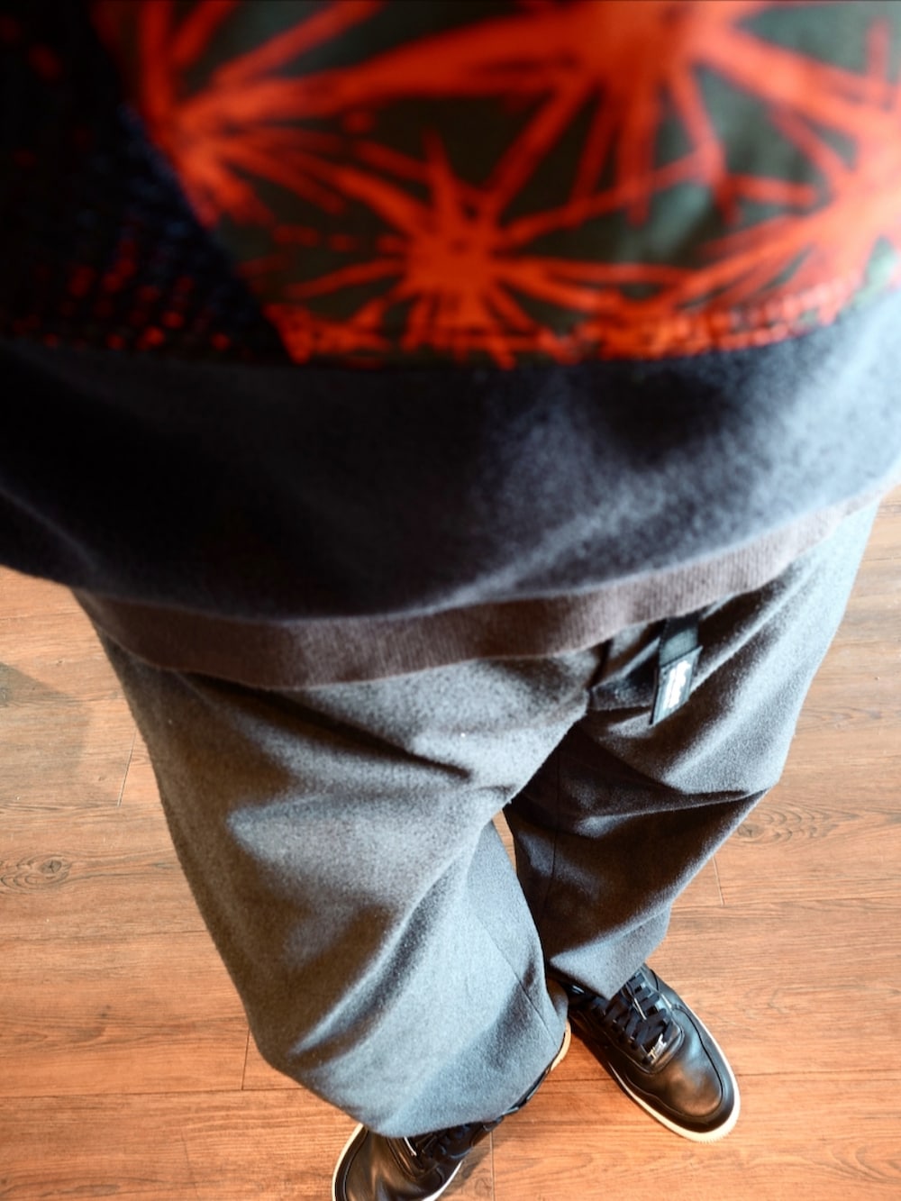 レッド系のブルゾン、グレー系のその他パンツ、ブラック系のスニーカーを着用したメンズの冬コーディネートの4枚目の写真