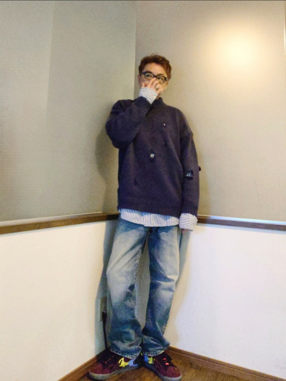 グレー系のチェスターコート、パープル系のニット/セーター、ホワイト系のシャツ/ブラウスを着用したメンズの秋コーディネートの2枚目の写真