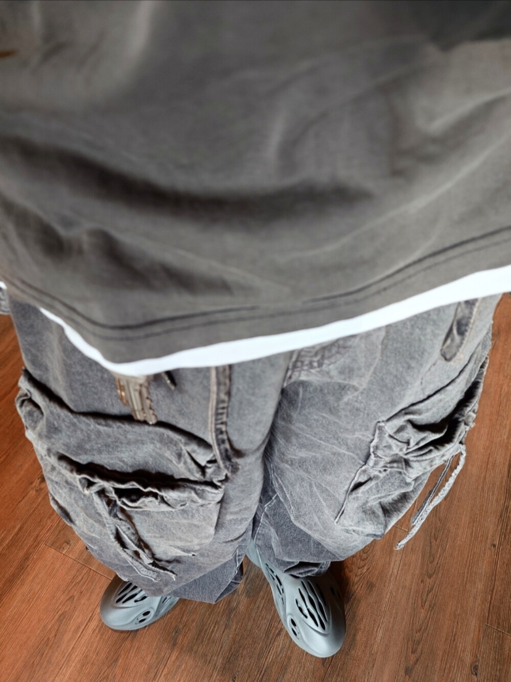 グレー系のシューズ、ブラック系のカーゴパンツ、ブラック系のTシャツ/カットソーを着用したメンズの夏コーディネートの3枚目の写真