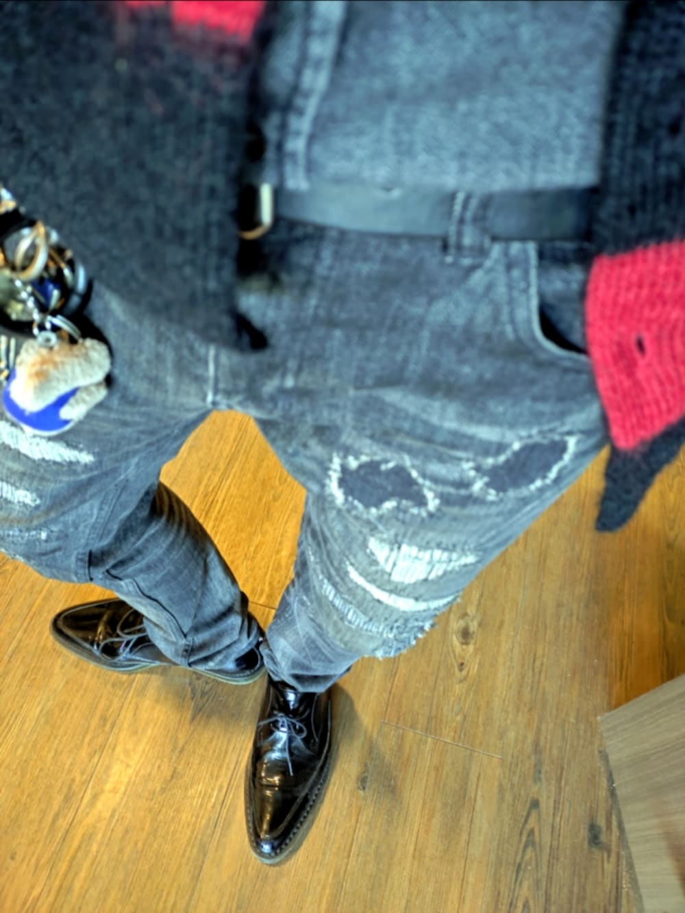 レッド系のカーディガン/ボレロ、ブラック系のシャツ/ブラウス、ブラック系のデニムパンツを着用したメンズの秋コーディネートの3枚目の写真