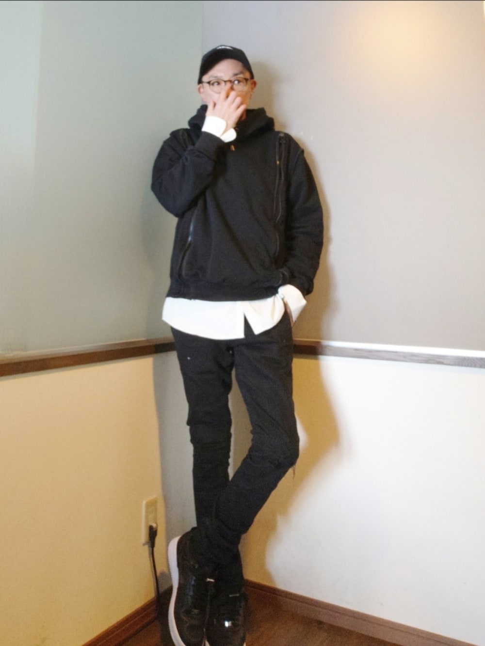 ブラック系のダウンジャケット/コート、ブラック系のパーカー、ブラック系のデニムパンツを着用したメンズの春コーディネートの2枚目の写真