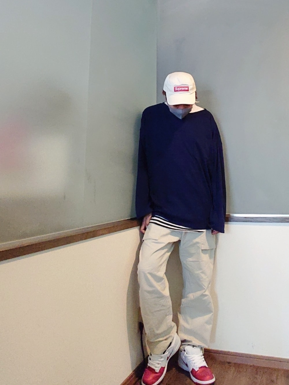 ブルー系のニット/セーター、ホワイト系のTシャツ/カットソー、ベージュ系のチノパンツを着用したメンズの夏コーディネートの2枚目の写真