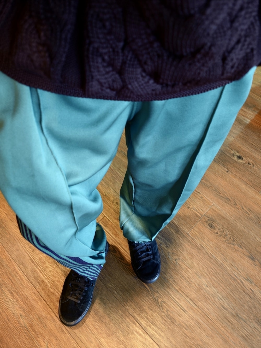 パープル系のニット/セーター、グリーン系のその他パンツ、ブラック系のスニーカーを着用したメンズの秋コーディネートの3枚目の写真