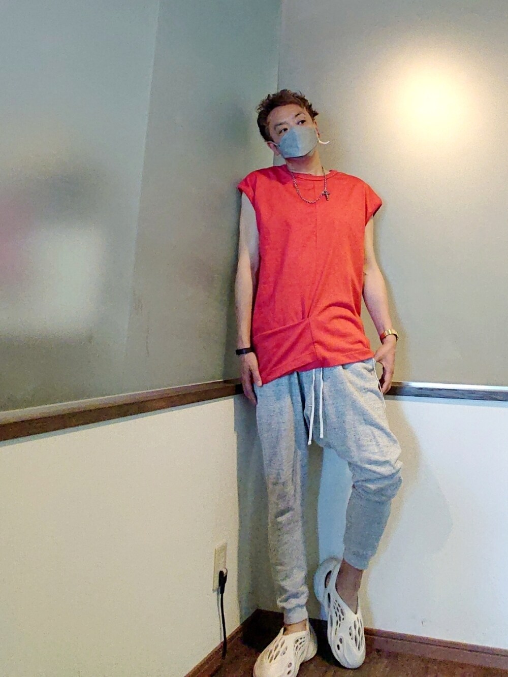 レッド系のTシャツ/カットソー、グレー系のスウェットパンツ、ホワイト系のスニーカーを着用したメンズの夏コーディネートの2枚目の写真