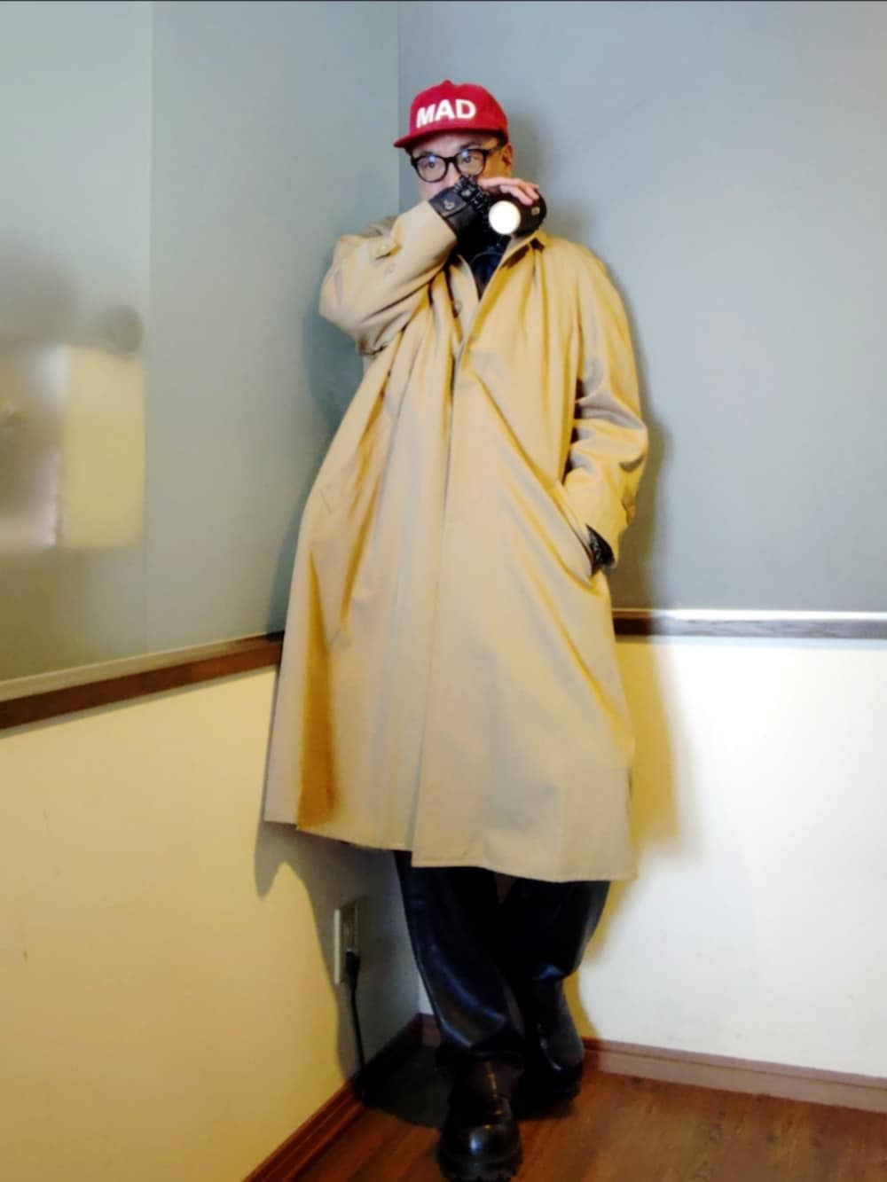 ブルー系のデニムジャケット、ベージュ系のトレンチコート、ブラック系のその他パンツを着用したメンズの冬コーディネートの2枚目の写真