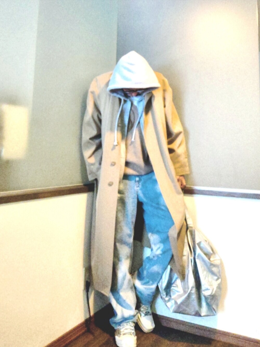 ベージュ系のニット/セーター、ベージュ系のトレンチコート、グレー系のパーカーを着用したメンズの春コーディネートの2枚目の写真