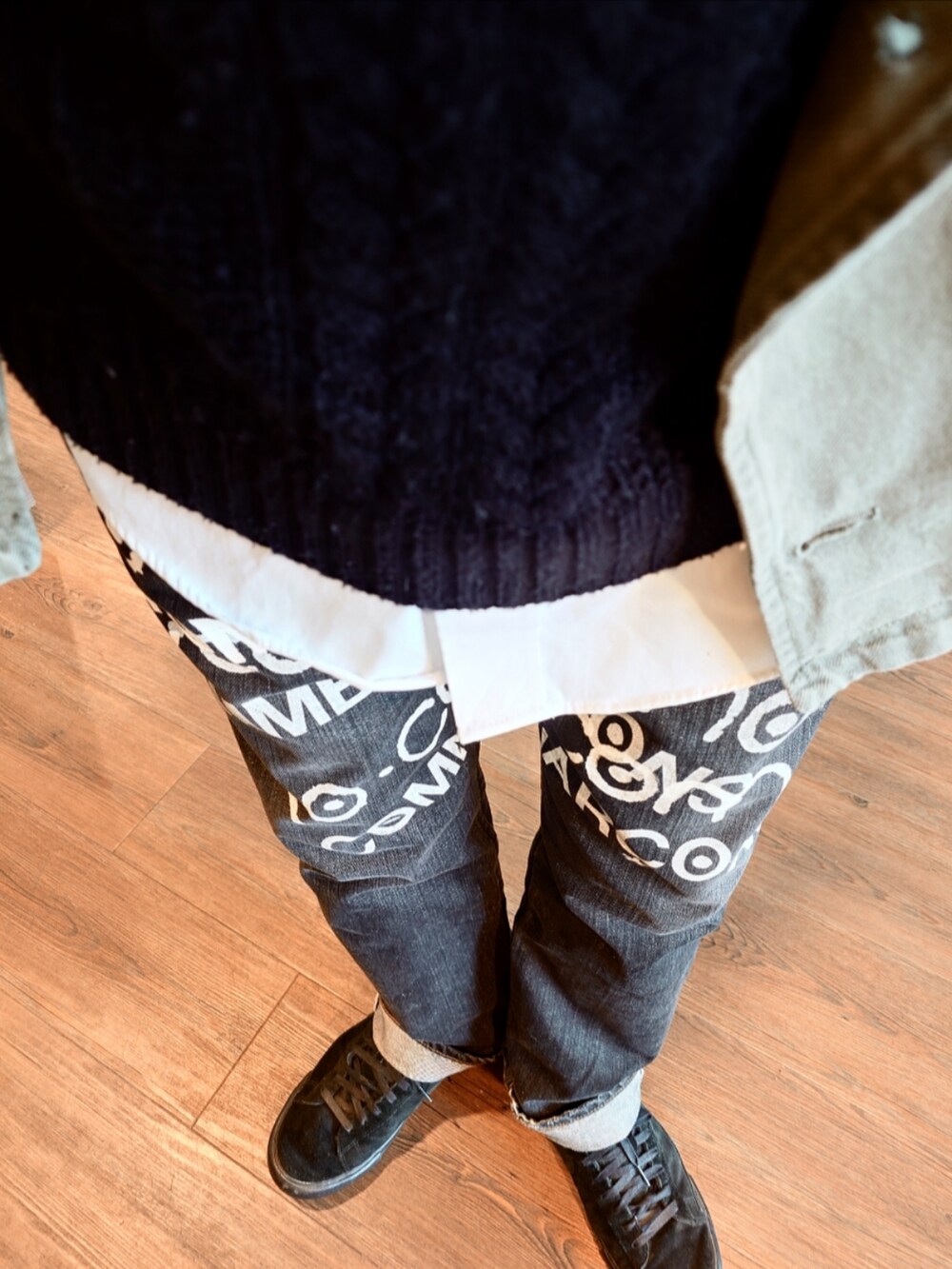 ブラック系のデニムパンツ、ホワイト系のシャツ/ブラウス、グリーン系のトレンチコートを着用したメンズの秋コーディネートの3枚目の写真