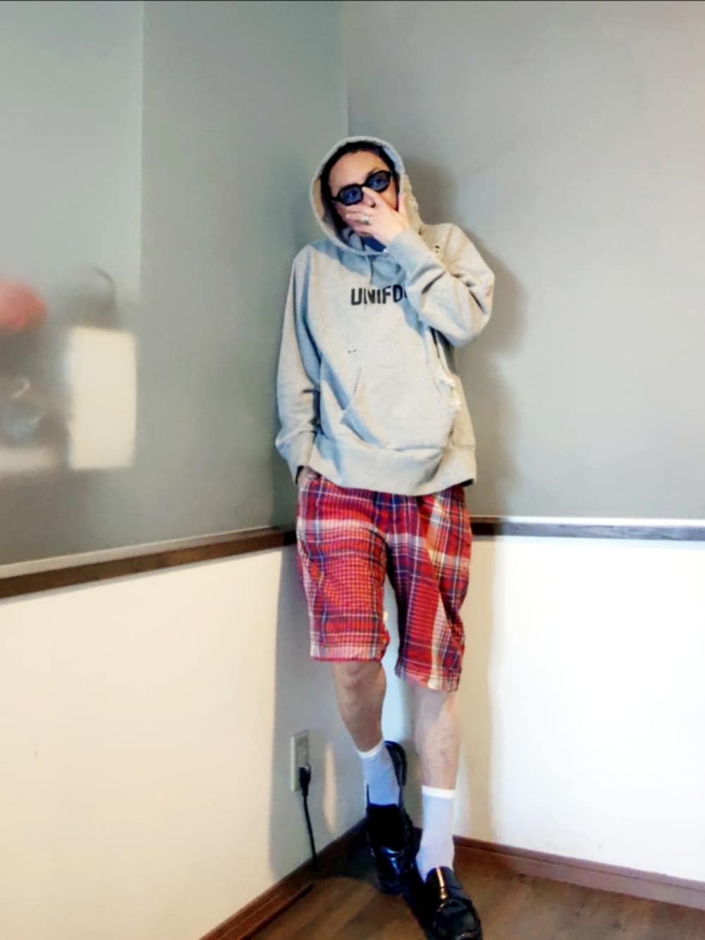 グレー系のパーカー、レッド系のその他パンツ、ブラック系のローファーを着用したメンズの夏コーディネートの2枚目の写真